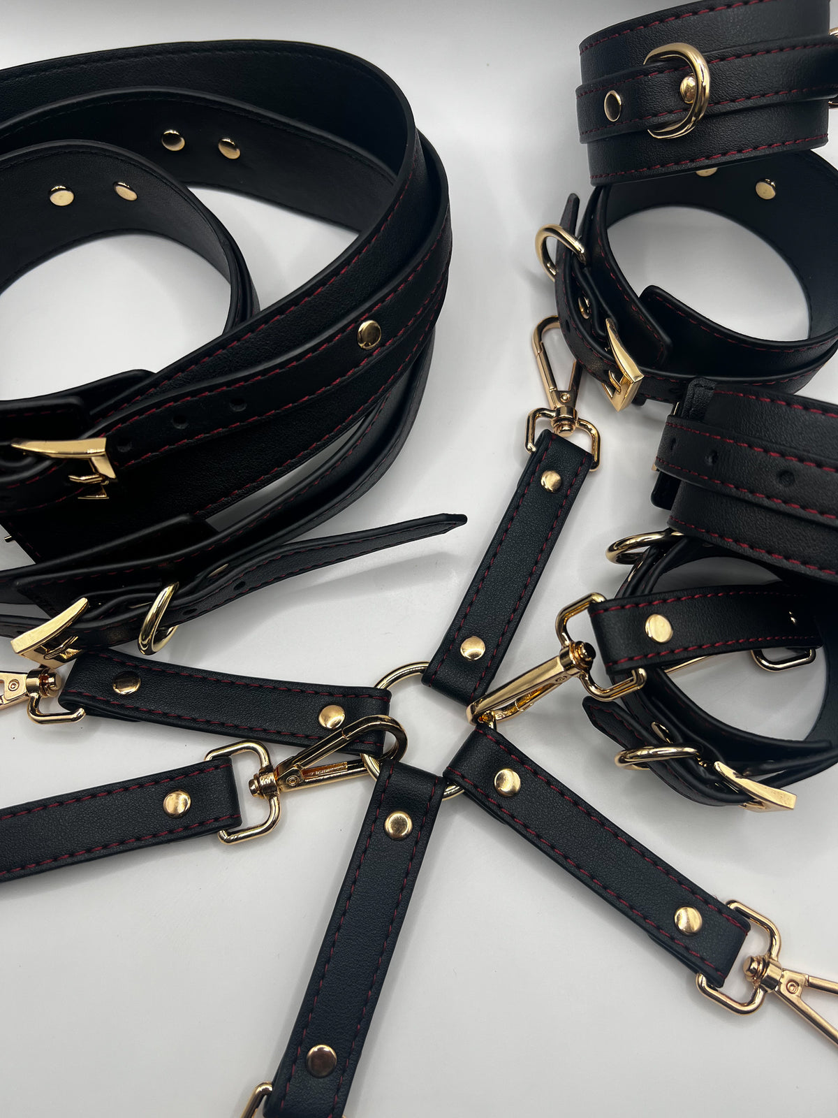 black leather restraints with gold detailing